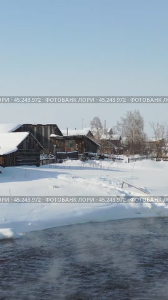 Vertical video of russian Altai country village Semiletka and river Koksha in winter season. The banks are covered with snow. Стоковое видео, видеограф Сергей Пристяжнюк (Serg Zastavkin) / Фотобанк Лори