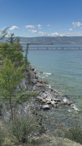 Vertical video of summer coast of Baikal Lake. View of Small Sea and rocky shore of Olkhon Island on July sunny day. Natural background. Summer travels and outdoors. Стоковое видео, видеограф Виктория Катьянова / Фотобанк Лори