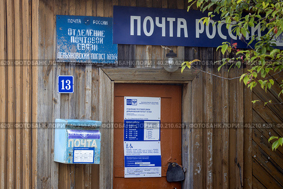 Вход в старое деревянное здание почты. Вывеска над входом: "Почта России". Почтовое отделение. Демьяновский погост, Бабушкинский район, Вологодская область, Россия. Редакционное фото, фотограф Андрей Степанов / Фотобанк Лори