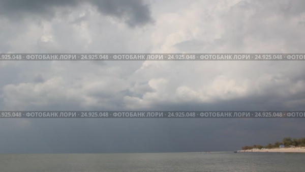 Вид на песчаную косу со стороны моря. Грозовые облака затягивают небо. Стоковое видео, видеограф Олег Хархан / Фотобанк Лори