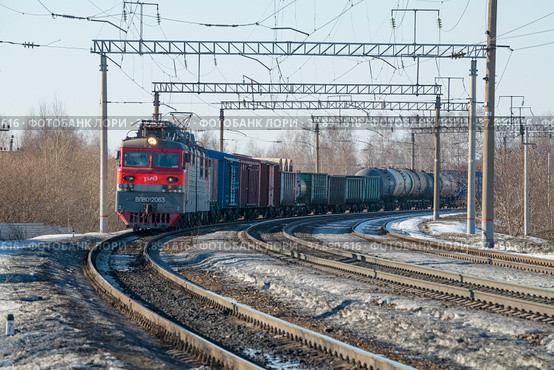 Вид на приближающийся грузовой поезд мартовским днем. Российские железные дороги (2022 год). Редакционное фото, фотограф Виктор Карасев / Фотобанк Лори