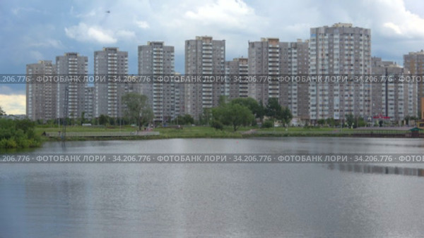 Вид на современные многоэтажные жилые дома на улице Димитрова со стороны Парка героев-пожарных облачным июльским днем. Санкт-Петербург, Россия (2020 год). Редакционное видео, видеограф Виктор Карасев / Фотобанк Лори