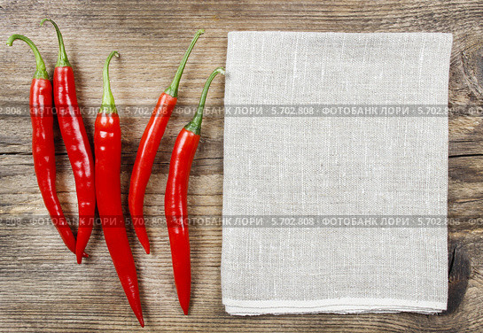 Вид сверху на красные перцы чили и джутовую ткань на столе. Стоковое фото, агентство BE&W Photo / Фотобанк Лори