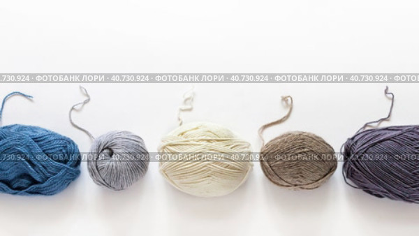 Video of skeins of different types of woolen yarn for hand knitting. Thread ends of different thicknesses and compositions: wool, acrylic, cotton and blends on white background. Flat lay, copy space. Стоковое видео, видеограф Виктория Катьянова / Фотобанк Лори