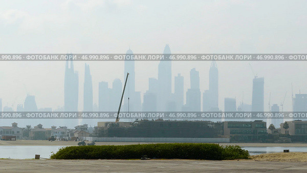 View from the river shore and embankment on skyscrapers in the morning haze. Стоковое фото, фотограф David Kashakhi / Фотобанк Лори