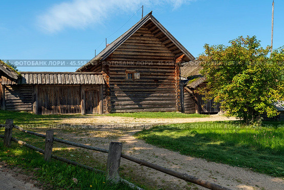 View of an ancient log building on the territory of the Pushkin village in Bugrovo of the Pushkin Museum-Reserve on a sunny summer day, Pushkinskiye Gory, Pskov region, Russia. Редакционное фото, фотограф Ula Ulachka / Фотобанк Лори