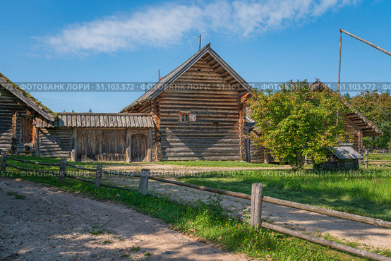 View of an ancient log building on the territory of the Pushkin village in Bugrovo of the Pushkin Museum-Reserve on a sunny summer day, Pushkinskiye Gory, Pskov region, Russia. Стоковое фото, фотограф Ula Ulachka / Фотобанк Лори