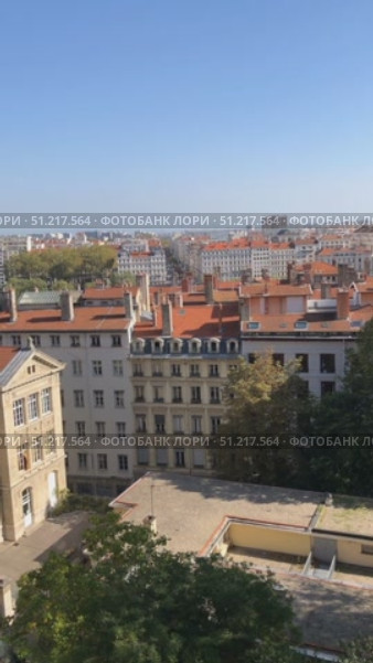 View of red-roofed buildings and river with distant cityscape under clear blue sky. Стоковое видео, видеограф Анастасия Золотницкая / Фотобанк Лори