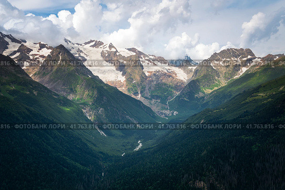 View of the Alibek Gorge, the Alibek River and the mountains of the Main Caucasian Ridge, opening from the upper station of the cable car system of the Dombay ski resort, Karachay-Cherkessia, Russia. Стоковое фото, фотограф Ula Ulachka / Фотобанк Лори