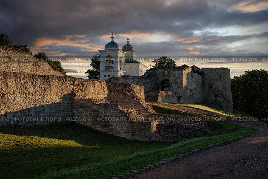 View of the wall of the Izborsk fortress, the Nikolsky Gate and St. Nicholas (Nikolsky) Cathedral (XIV-XVII century) on a sunny summer morning, Izborsk, Pskov region, Russia. Стоковое фото, фотограф Ula Ulachka / Фотобанк Лори