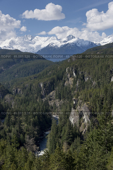 View of valley with mountains against cloudy sky, BC Coast, Coast Mountains, Squamish, British Columbia, Canada. Стоковое фото, агентство Ingram Publishing / Фотобанк Лори