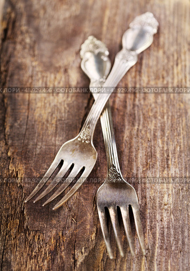 Vintage silverware forks lying on rustic wooden table. Стоковое фото, агентство Ingram Publishing / Фотобанк Лори