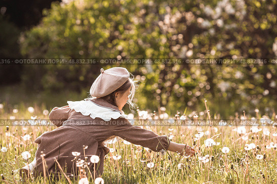 Vintage women's accessories and retro-style clothing. A small, beautiful girl with bows in her hair, in a beige dress and a beret outdoors. Стоковое фото, фотограф Photojuli / Фотобанк Лори