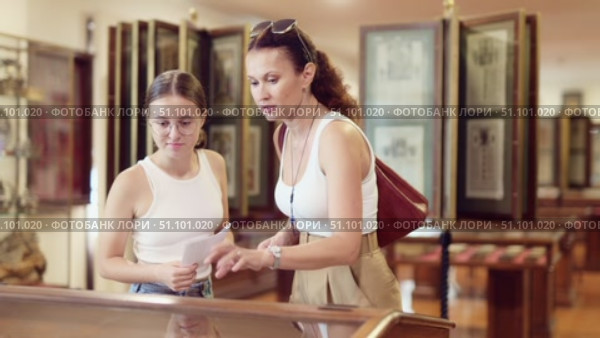 Visitors stands near horizontal glass display case and examines valuable exhibit. Стоковое видео, видеограф Яков Филимонов / Фотобанк Лори