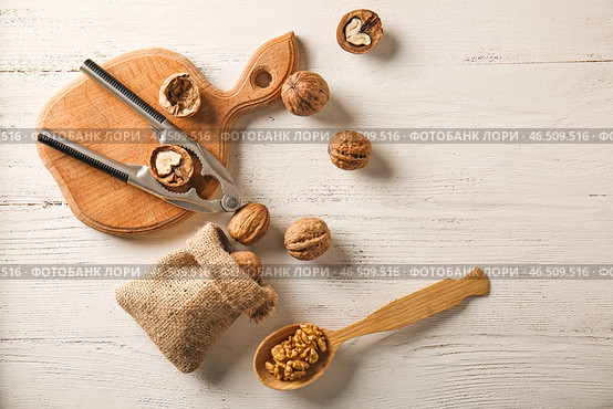 Вкусные грецкие орехи с Щелкунчиком на белом столе. Стоковое фото, фотограф Pixel_shot / Фотобанк Лори