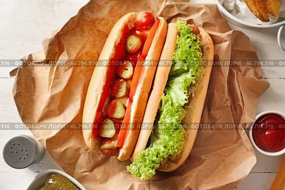 Вкусные хот-доги на белом столе. Стоковое фото, фотограф Pixel_shot / Фотобанк Лори