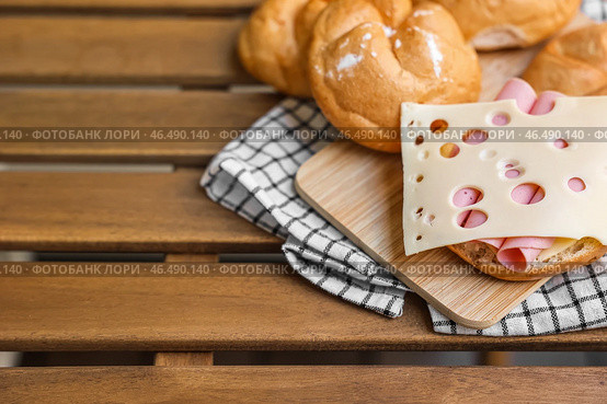 Вкусные роллы кайзер с ветчиной и сыром на деревянной доске. Стоковое фото, фотограф Pixel_shot / Фотобанк Лори