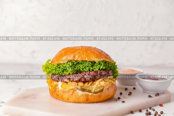 Вкусный бургер и соусы на светлом фоне. Стоковое фото, фотограф Pixel_shot / Фотобанк Лори