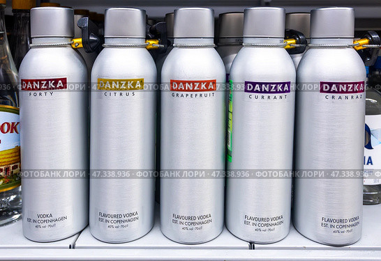Водка Danzka в блестящих металлических бутылках, наполненных ароматизированными спиртными напитками, стоит на полке магазина. Редакционное фото, фотограф FotograFF / Фотобанк Лори