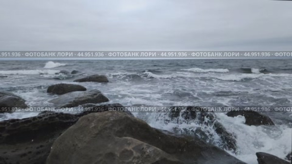 Волны разбиваются о камни. Бурное море. Побережье в пасмурную погоду. Мощные потоки воды и гигантские камни. Тихий океан, Японское море. Стоковое видео, видеограф Ирина / Фотобанк Лори