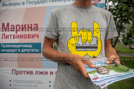 Волонтер предвыборного штаба Марины Ливинович кандидата в депутаты в Государственную Думу РФ от партии "Яблоко" раздает агитационные листовки в городе Москве, Россия (2021 год). Редакционное фото, фотограф Николай Винокуров / Фотобанк Лори
