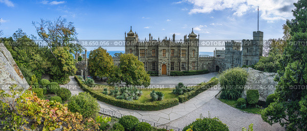 Vorontsov Palace in Alupka, Crimea. Panoramic view of castle with blue sky background. Yucca bushes and trees are in foreground (2021 год). Стоковое фото, фотограф Igor Tichonow / Фотобанк Лори
