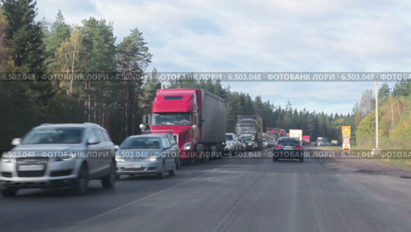 Встречные автомобили стоят в заторе, вид из едущей машины. Трасса "Скандинавия", Санкт-Петербург - Выборг (2014 год). Редакционное видео, видеограф Кекяляйнен Андрей / Фотобанк Лори