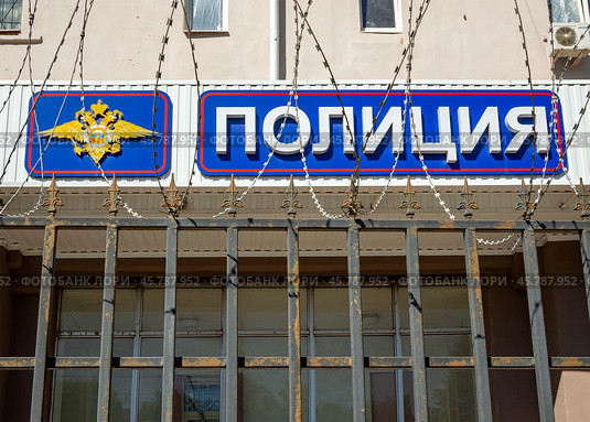 Вывеска отделения полиции на фоне спирали из колючей проволоки (2024 год). Редакционное фото, фотограф Вячеслав Палес / Фотобанк Лори