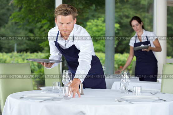 waiter setting wedding table at restaurant. Стоковое фото, агентство Ingram Publishing / Фотобанк Лори