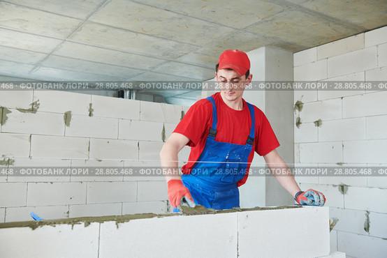 walling. bricklayer installing autoclaved aerated concrete blocks. Стоковое фото, фотограф Дмитрий Калиновский / Фотобанк Лори