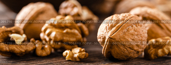 Walnuts. Kernels and whole nuts on wooden rustic table closeup, banner. Стоковое фото, агентство Ingram Publishing / Фотобанк Лори