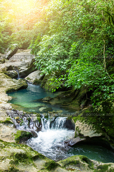 Waterfalls on the mountain river. Summer landscape. Rays of the sun through the foliage. Стоковое фото, фотограф Евгений Ткачёв / Фотобанк Лори