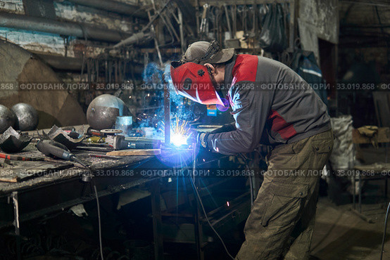 Welder works in a small workshop. Стоковое фото, фотограф Евгений Харитонов / Фотобанк Лори