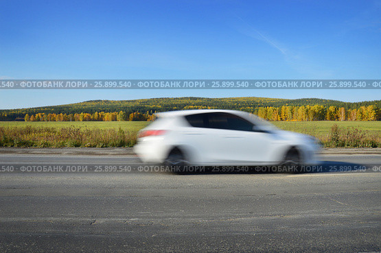 White car rides on the road at high speed. Стоковое фото, фотограф Юлия Дьякова / Фотобанк Лори