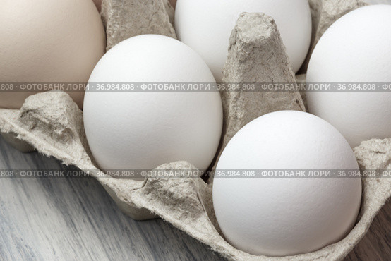 White chicken egg in a package close-up. Source of calcium, protein, lecithin, choline, vitamin, potassium, magnesium, zinc, selenium, copper, iodine, chromium, fluorine. Стоковое фото, фотограф Светлана Евграфова / Фотобанк Лори