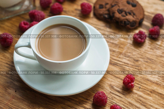 white cup coffee with chocolate cookies raspberries wooden background. Стоковое фото, агентство Ingram Publishing / Фотобанк Лори