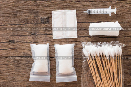 white medical cotton gauze bandage syringe pack cotton swab wooden table. Стоковое фото, агентство Ingram Publishing / Фотобанк Лори