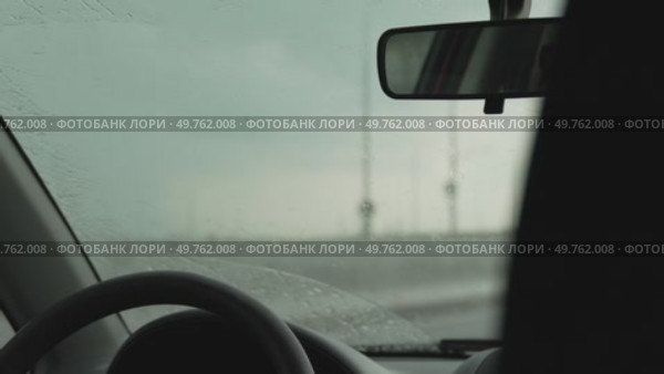 Windshield wipers rain: Driving inside vehicle during rainy day, wipers are operating for better visibility. Стоковое видео, видеограф svetograph / Фотобанк Лори