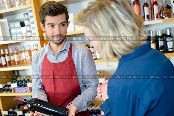wine seller making recommendation to customer. Стоковое фото, агентство Ingram Publishing / Фотобанк Лори