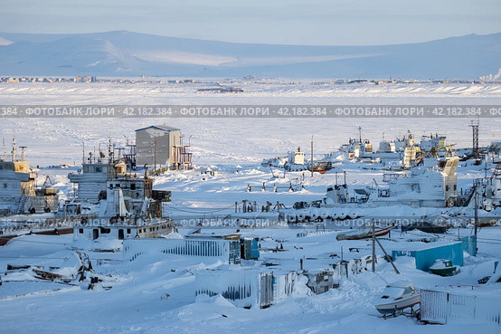 Winter arctic landscape. A view of the snow-covered berths and winter anchorage of ships, barges, yachts and boats on the coast of the frozen estuary. Alexander Spit, Anadyr, Chukotka, Siberia, Russia. Стоковое фото, фотограф Андрей Степанов / Фотобанк Лори