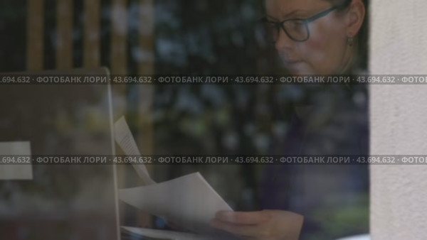 With pen in hand businesswoman sits at table with laptop making notes in papers. Making notes integral part of workflow organize thoughts action plans steer business towards prosperity making notes. Стоковое видео, видеограф Olesia Kondrateva / Фотобанк Лори
