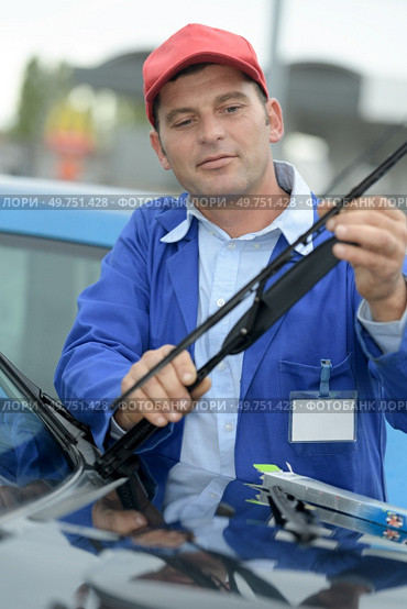woker changing windscreen wiper on a car. Стоковое фото, агентство Ingram Publishing / Фотобанк Лори