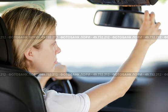 woman adjusting rear view mirror. Стоковое фото, агентство Ingram Publishing / Фотобанк Лори