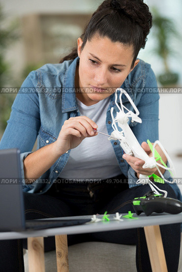 woman assembling drone following instructions on laptop. Стоковое фото, агентство Ingram Publishing / Фотобанк Лори
