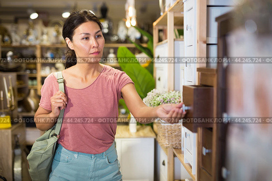 Woman choosing small cabinet in store. Стоковое фото, фотограф Яков Филимонов / Фотобанк Лори