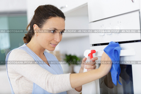 woman cleaning oven with spray. Стоковое фото, агентство Ingram Publishing / Фотобанк Лори