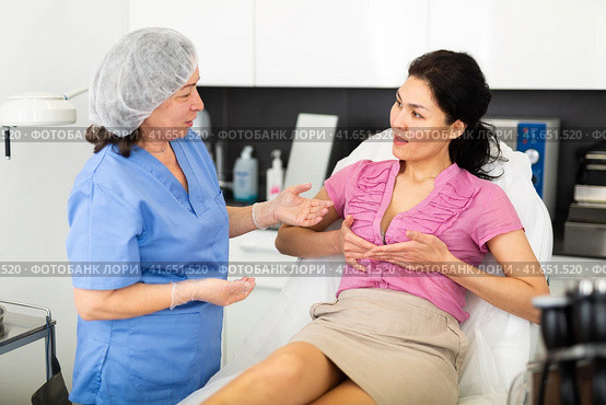 Woman consulting with cosmetologist about breast augmentation procedures. Стоковое фото, фотограф Яков Филимонов / Фотобанк Лори