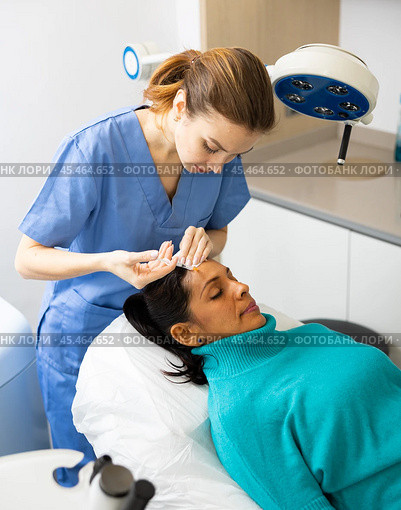 Woman cosmetician giving face injections of botulinum toxin for young woman. Стоковое фото, фотограф Яков Филимонов / Фотобанк Лори