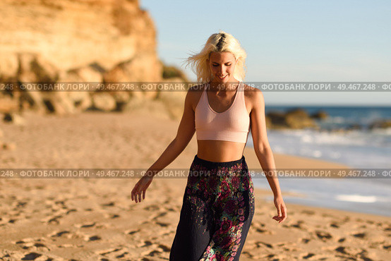 Woman enjoying the sunset on a beautiful beach in Cadiz, Andalusia, Spain. Young female opening arms and breathing the sea air.. Woman enjoying the sunset on a beautiful beach. Стоковое фото, агентство Ingram Publishing / Фотобанк Лори