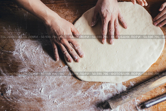 Woman hands kneading dough on the table. Стоковое фото, агентство Ingram Publishing / Фотобанк Лори